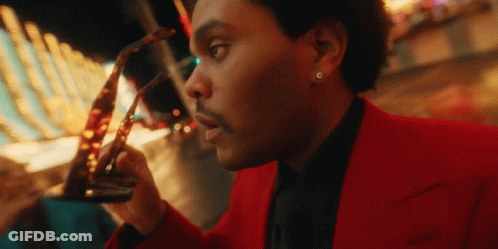 A Man In A Red Suit Holds A Pair Of Glasses GIF