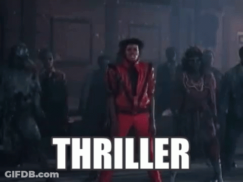 A Man In A Red Suit Is Dancing In Front Of A Crowd Of People With The Word Thriller Written In White Letters . GIF