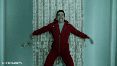 A Man In A Red Suit Is Laying On A Wall Covered In Money And Laughing . GIF