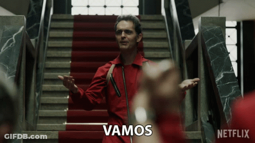 A Man In A Red Suit Is Standing On A Set Of Stairs With A Netflix Logo Behind Him GIF
