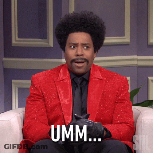 A Man In A Red Suit Says Umm While Sitting On A Chair GIF
