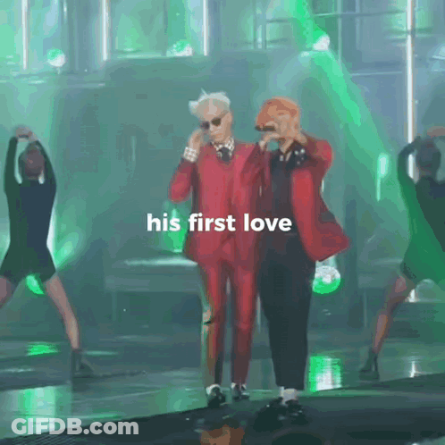 A Man In A Red Suit Stands Next To Another Man With The Words His First Love Written On The Bottom GIF