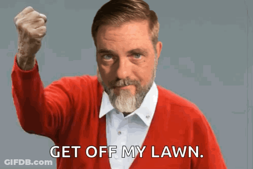 A Man In A Red Sweater Holds His Fist Up And Says " Get Off My Lawn " GIF