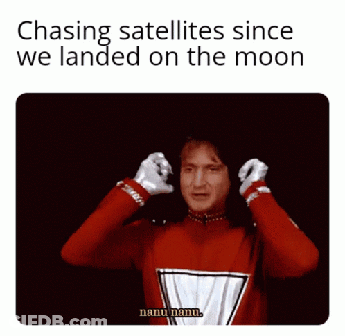 A Man In A Red Sweater Is Covering His Ears With His Hands While Saying Chasing Satellites Since We Landed On The Moon GIF