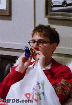 A Man In A Red Sweater Is Holding A Bag That Says Party GIF