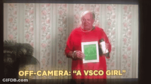 A Man In A Red Sweater Is Holding A Cup And A Piece Of Paper In Front Of A Camera . GIF