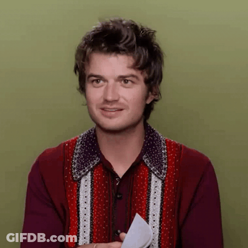 A Man In A Red Sweater Is Holding A Piece Of Paper In His Hand GIF