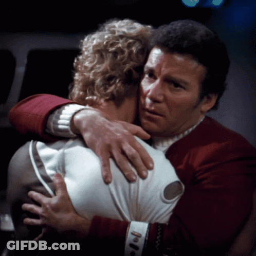 A Man In A Red Sweater Is Hugging Another Man In A White Shirt GIF