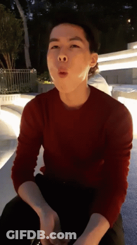 A Man In A Red Sweater Is Making A Face GIF