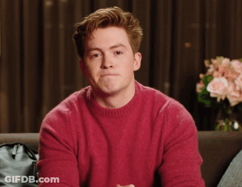 A Man In A Red Sweater Is Making A Funny Face GIF