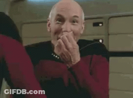 A Man In A Red Sweater Is Making A Funny Face While Standing In A Room . GIF