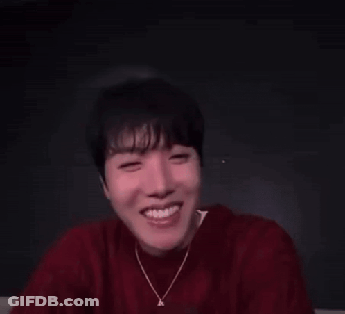 A Man In A Red Sweater Is Making A Funny Face With His Eyes Closed . GIF