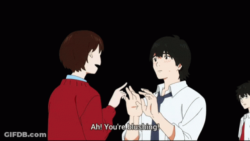 A Man In A Red Sweater Is Talking To Another Man In A White Shirt Who Is Blushing GIF