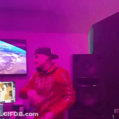 A Man In A Red Sweatshirt Is Dancing In Front Of A Purple Light GIF