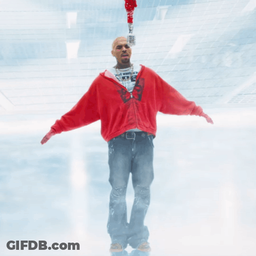 A Man In A Red Sweatshirt Is Holding A Microphone GIF