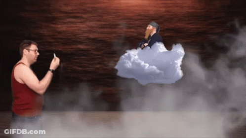 A Man In A Red Tank Top Stands In Front Of A Cloud With A Bearded Man In It GIF