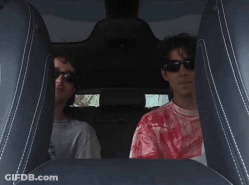 A Man In A Red Tie Dye Shirt Sits In The Back Seat Of A Car GIF