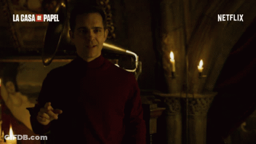 A Man In A Red Turtleneck Stands In Front Of A Netflix Logo GIF