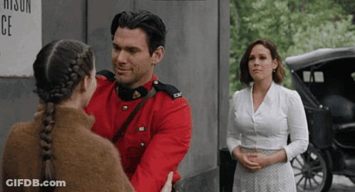A Man In A Red Uniform Is Hugging A Girl In A Braid GIF