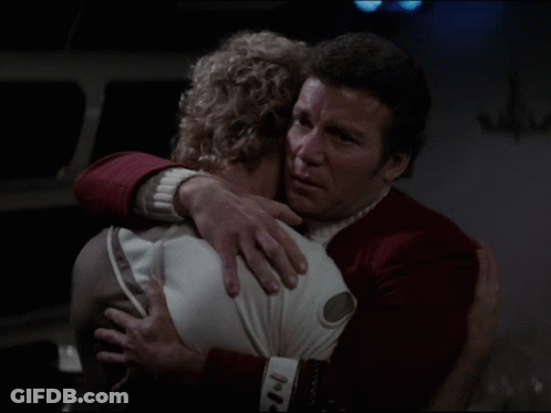 A Man In A Red Uniform Is Hugging A Woman GIF