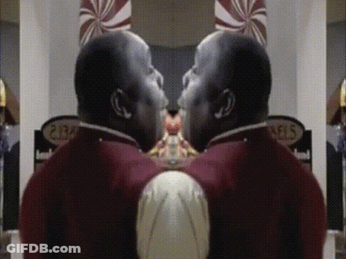 A Man In A Red Uniform Is Standing In Front Of A Sign That Says ' Pears ' GIF