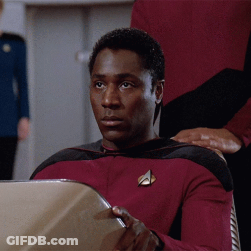 A Man In A Red Uniform With A Star Trek Badge GIF