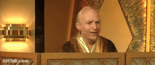 A Man In A Robe Is Sitting In Front Of A Window . GIF