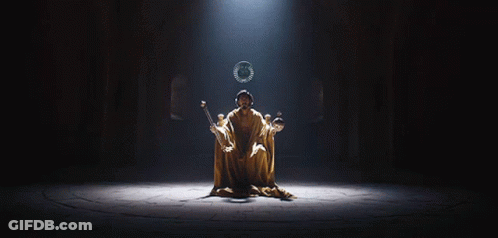 A Man In A Robe Is Sitting On A Throne With A Wreath On His Head GIF