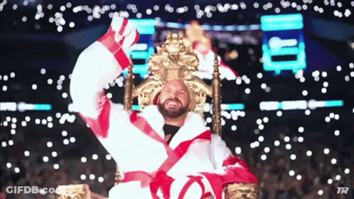 A Man In A Robe Is Sitting On A Throne With His Arms Up GIF