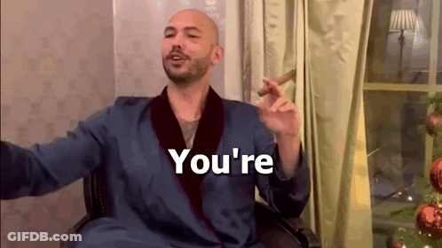 A Man In A Robe Is Smoking A Cigar And Saying `` You 'Re '' While Sitting In A Chair . GIF