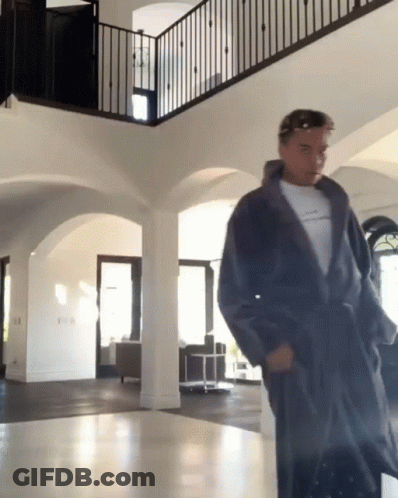 Man In Robe Standing In Hallway GIF