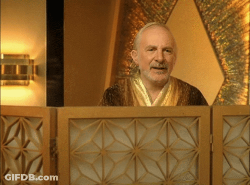A Man In A Robe Stands Behind A Wooden Partition GIF