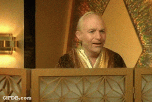 A Man In A Robe Stands Behind A Wooden Partition GIF