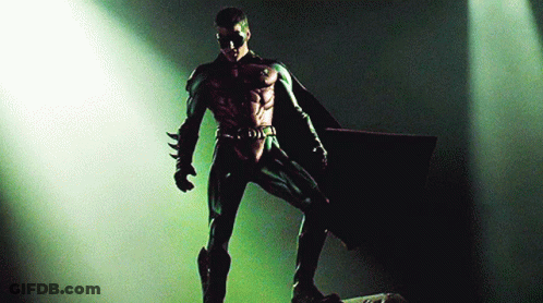 A Man In A Robin Costume Is Standing In A Spotlight GIF