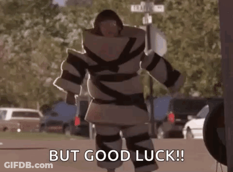 A Man In A Robot Costume Is Walking Down The Street And Saying `` But Good Luck '' . GIF