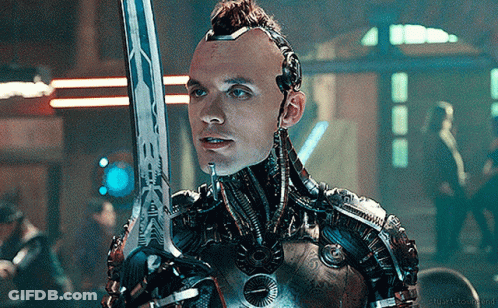 A Man In A Robotic Suit Is Holding A Sword In His Right Hand GIF