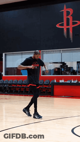 A Man In A Rockets T-Shirt Is Walking On A Basketball Court GIF