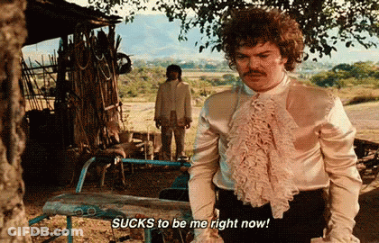 A Man In A Ruffled Shirt Says Sucks To Be Me Right Now While Standing Next To An Ironing Board . GIF