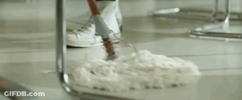 A Man In A Sailor Outfit Is Standing In Front Of A Counter In A Restaurant Holding A Mop . GIF