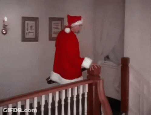 A Man In A Santa Claus Costume Is Walking Down A Set Of Stairs . GIF