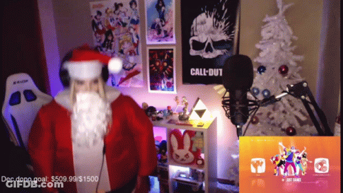 A Man In A Santa Costume Stands In Front Of A Microphone In A Room With A Call Of Duty Poster On The Wall GIF