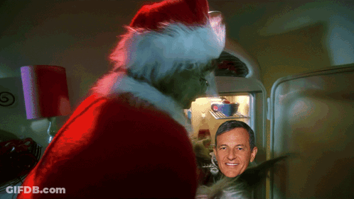 A Man In A Santa Hat Stands In Front Of A Refrigerator GIF