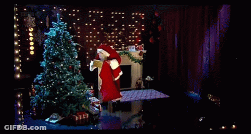 A Man In A Santa Suit Is Holding A Christmas Card With A Christmas Tree On It GIF
