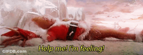 A Man In A Santa Suit Is Laying On The Ground In The Snow . GIF