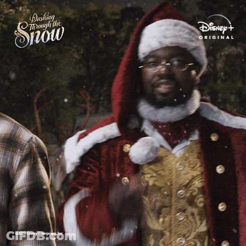 A Man In A Santa Suit Is Standing In Front Of A Sign That Says Dash Through The Snow GIF