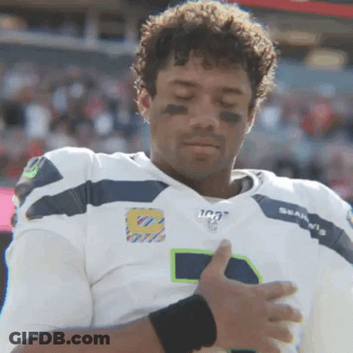 A Man In A Seahawks Jersey Holds His Hands Over His Heart GIF