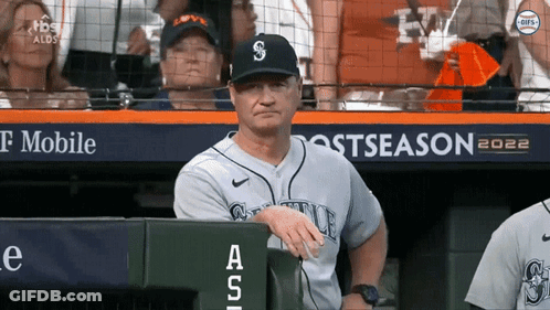 A Man In A Seattle Baseball Uniform Sits In The Dugout During A Game GIF
