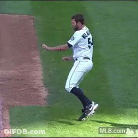 A Man In A Seattle Mariners Uniform Is Dancing On The Field GIF