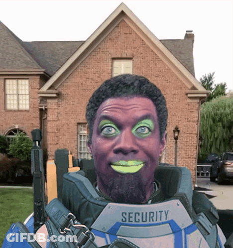 A Man In A Security Suit Is Smiling In Front Of A Brick Building GIF