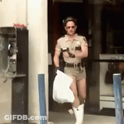 A Man In A Sheriff 'S Uniform Is Carrying A Bag GIF